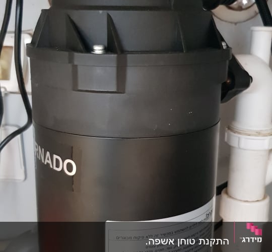 מכשיר טוחן אשפה מתחת לכיור עם צינורות חיבור